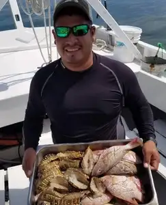 A man holding a box of fish on the boat.